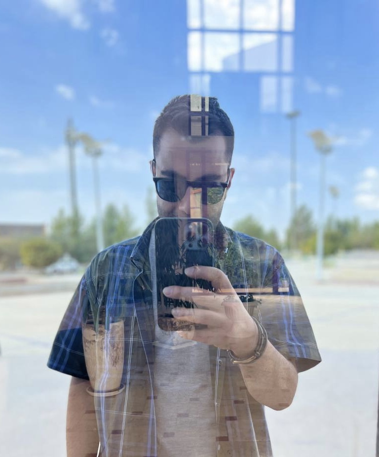 Ali Akhtari reflected in a window while taking a portrait
